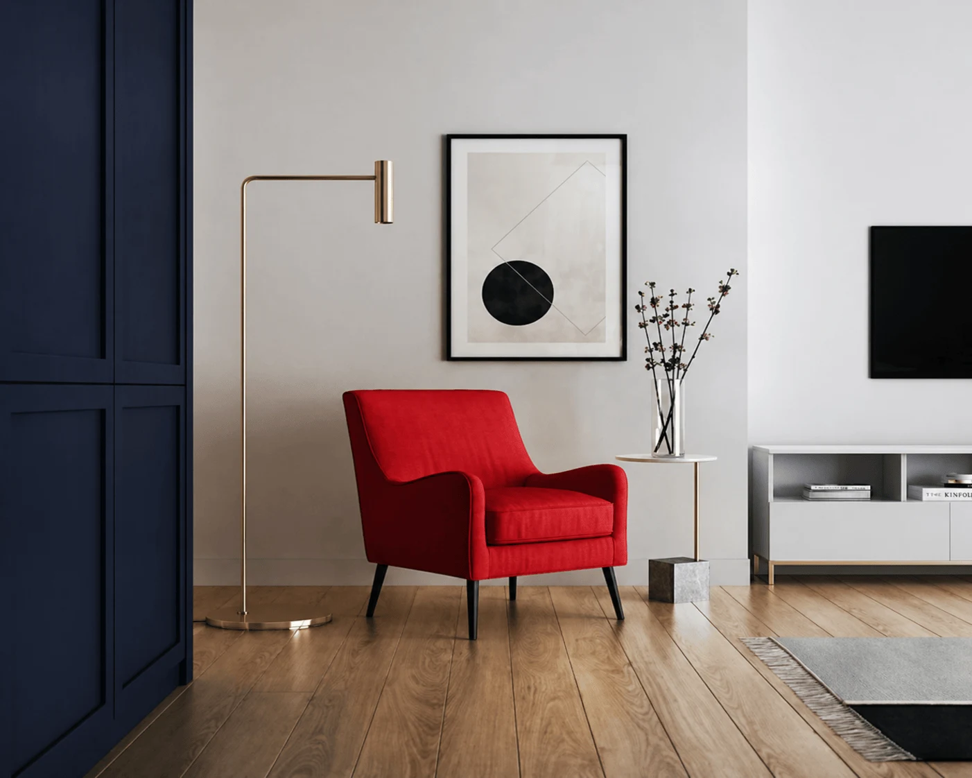 A minimalist interior corner featuring a red accent chair, modern floor lamp, framed wall art, wooden flooring, and clean contemporary decor.